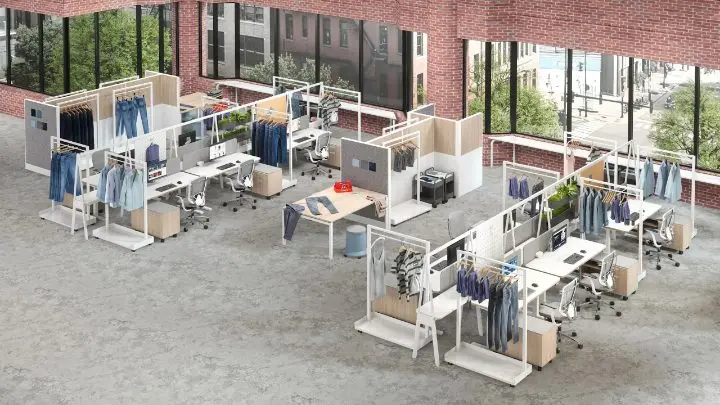 Axonometric view of a retail and back-of-house layout, with garment rails and merchandising displays wrapped around bench workstations, mobile pedestals and task chairs, against a brick-and-glass storefront