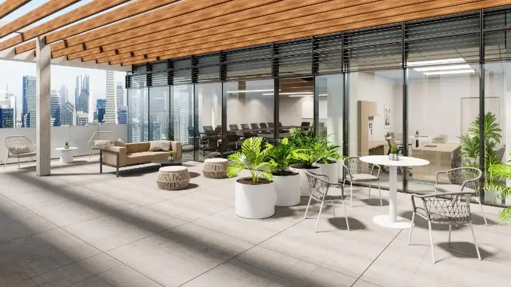 Custom outdoor terrace modeled from the project drawings, with a wood slat pergola, woven lounge chairs, poufs, round side tables and planting, opening onto a glazed conference room and a city skyline