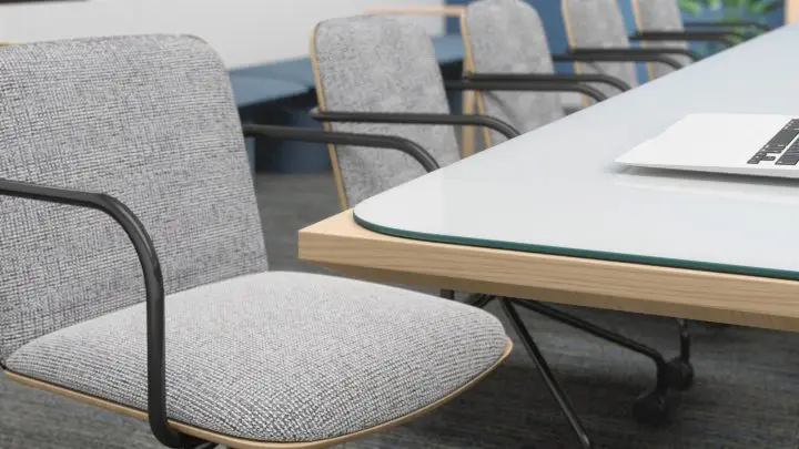 Close-up rendering of wood-shell guest chairs with grey upholstered seats and black cantilever frames, pulled up to a glass-topped table with a wood edge