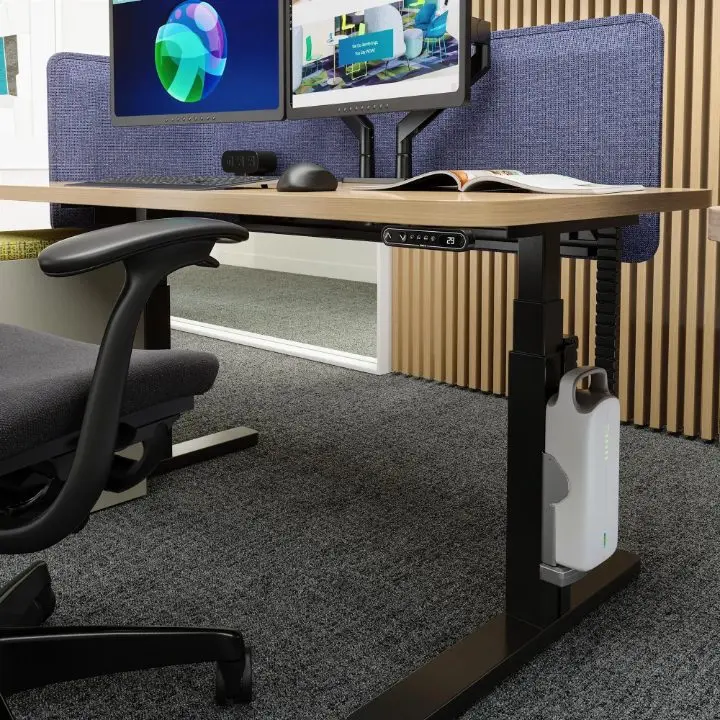 Close-up rendering of the Untethered mobile battery mounted to a Teknion height-adjustable table, shown with the Swerve dual monitor arm, height control display and acoustic screen