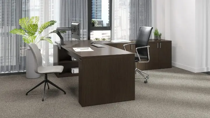 Executive private office with a Teknion Dossier desk and credenza in dark veneer, shown with a Swerve dual monitor arm, a Stylex Sava task chair and an OFS guest chair, set against sheer window treatments and a city view