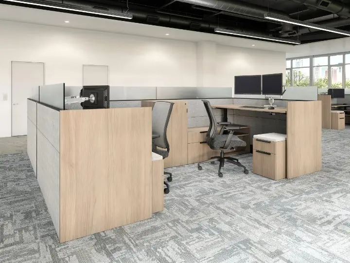 Reception and open-plan area in a pre-designed setting with a light-oak reception desk with a transaction counter, dual monitors, mesh task chairs, a mobile pedestal and lateral filing, under an exposed ceiling
