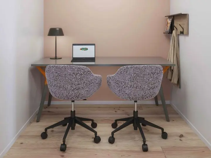 Two-person touchdown space with a Teknion UpStage table, Kuskoa chairs in full upholstery and a Complements desk lamp, set into an alcove with a wall-mounted coat rack and shelf
