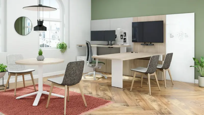 Private office rendering with a wood meeting table, monitor arms, TV wall and round guest table, Anomatics